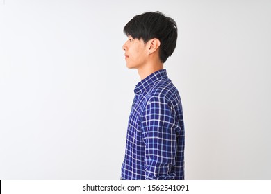 Young Chinese Man Wearing Casual Blue Shirt Standing Over Isolated White Background Looking To Side, Relax Profile Pose With Natural Face With Confident Smile.