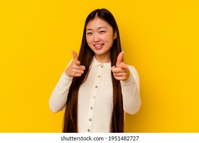 Young chinese woman isolated on yellow background cheerful smiles pointing to front. - Shutterstock ID 1951482727