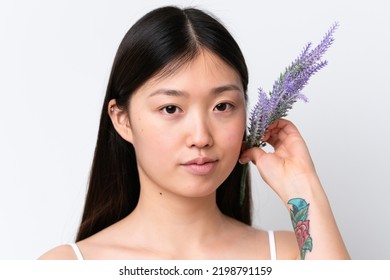 Young Chinese Woman Isolated On White Background Holding A Lavender Plant. Close Up Portrait