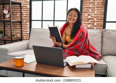 Young Chinese Woman Studying Sitting On Sofa At Home