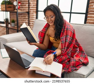 Young Chinese Woman Studying Sitting On Sofa At Home