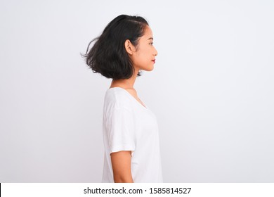 Young Chinese Woman Wearing Casual T-shirt Standing Over Isolated White Background Looking To Side, Relax Profile Pose With Natural Face With Confident Smile.