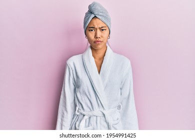 Young chinese woman wearing shower towel cap and bathrobe depressed and worry for distress, crying angry and afraid. sad expression.  - Powered by Shutterstock