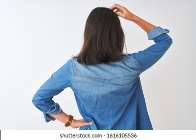 Young chinese woman wearing striped t-shirt and denim shirt over isolated white background Backwards thinking about doubt with hand on head - Powered by Shutterstock