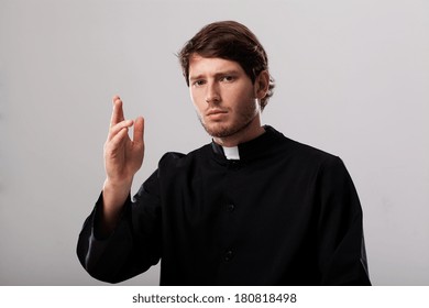 Young Christian Priest Is Praying To Cross