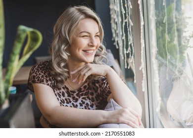 A Young Chubby Blonde Woman In A Leopard Blouse Drinks Coffee From In A Cafe Sits Near A Large Panoramic Window. Very Emotional Portrait. Of Pretty Plus Size Girl