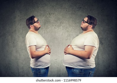 Young Chubby Man Looking At Fat Himself Feeling Bloated. Diet And Nutrition Choice  Healthy Lifestyle Concept