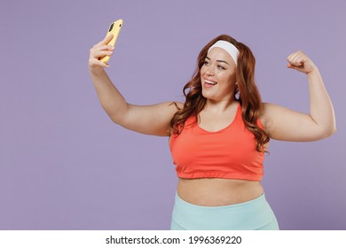 Young Chubby Overweight Plus Size Big Fat Fit Woman In Red Top Warm Up Training Hold Yoga Mat Do Selfie Shot On Mobile Phone Show Muscles Isolated On Purple Background Home Gym Workout Sport Concept