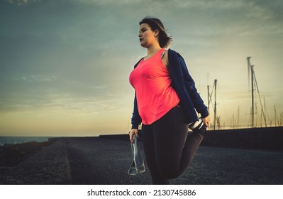 Young Chubby Woman Sport Workout On The Harbor Bridge Stretching Legs - Healthy Concept Of Curvy People Determination For Weight Loss