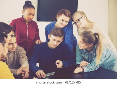 young classmates having difficult project to complete during class sits by the table