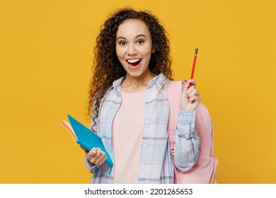 Young clever black teen girl student she wear casual clothes backpack bag write in notebook hold finger up great new idea isolated on plain yellow background. High school university college concept - Shutterstock ID 2201265653