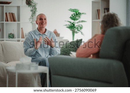 Young client actively engaging in conversation, smiling and gesturing, during a mental health counseling session with a therapist