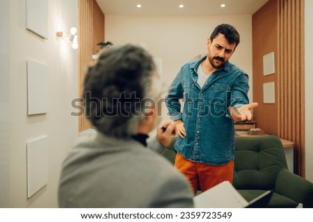 A young client is rejecting help and going through resistance with his shrink at the doctor's office. A patient is rejecting medication and therapy while standing at a shrink's office.