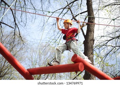 Young Climber Skilfully Go On A Suspension Bridge In High Ropes Course.