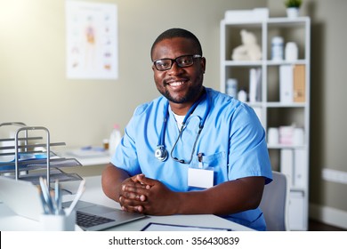 Young Clinician In Uniform Sitting At Workplace