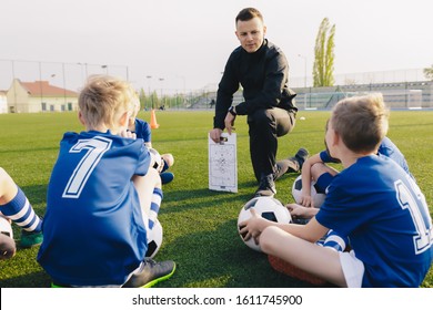 Young Coach Explaining Soccer Positions And Match Tactics To Youth. Kids Football Team Coaching. Children On Soccer Training