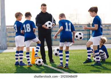 Junge Trainer unterrichten Kinder auf dem Fußballfeld. Der Trainer erklärt den Schülern die Trainingsregeln. Fußballtrainer, der Kinder trainiert. Fußball-Trainingseinheit für Kinder. Fußball-taktische Ausbildung. 