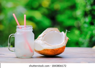 Young coconut and fresh coconut drink in a glass on a wooden table