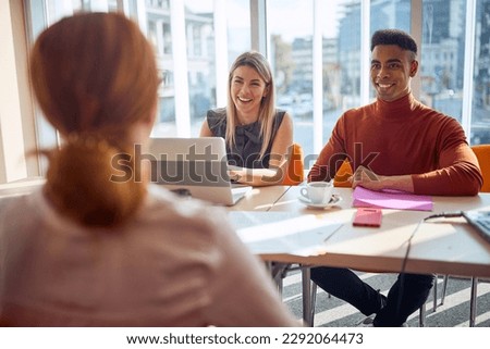 Young colleagues in a commission having a pleasant talk with a young female applicant in a relaxed atmosphere during an interview for a job. Business, people, company
