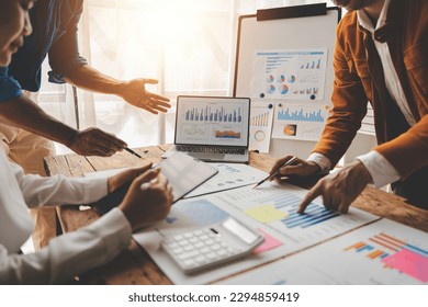 Young colleagues discuss business and analytical price charts using calculators and laptops to calculate financial, tax, accounting, statistics and analytical research ideas. - Powered by Shutterstock