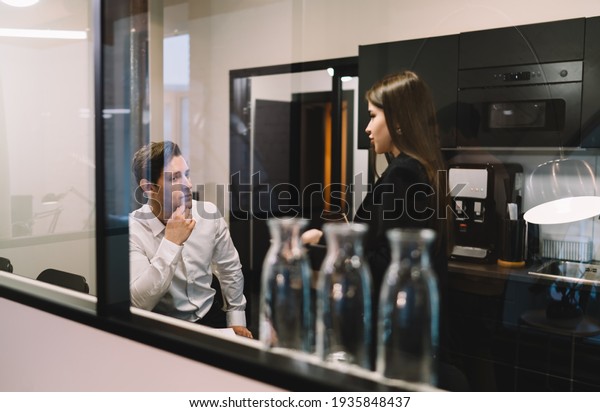 Young colleagues in formal outfit thinking and\
speaking about important details in business in convenient modern\
restroom of contemporary\
office