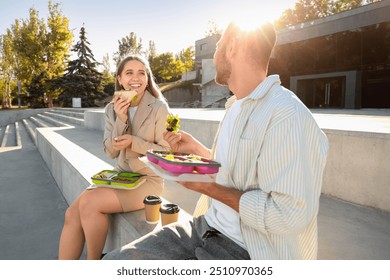 Young colleagues having lunch outdoors - Powered by Shutterstock