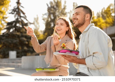 Young colleagues having lunch outdoors - Powered by Shutterstock