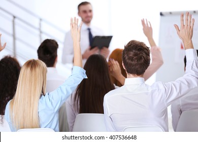 Young Colleagues Raising Hands At The Business Meeting In Office