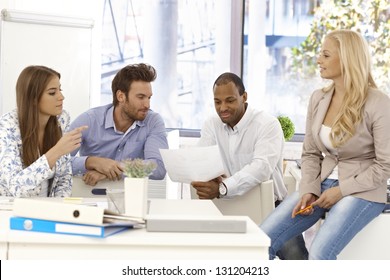 Young Colleagues Working Together In Bright Office.