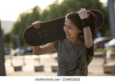 Young College Girl Walking Happily After Playing Skateboarding - Stock Photo