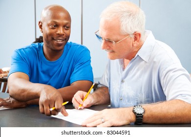 Young College Student Tutoring An Older Classmate.