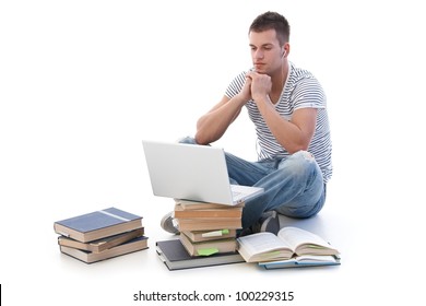 Young College Student Using Laptop, Sitting Among Books, Using Headset.