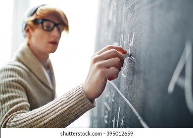 Young College Student Writing On Blackboard During A Math Class