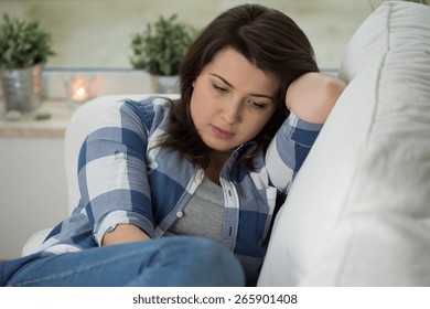 Young Concerned Woman Sitting On Psychologist's Couch