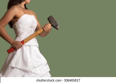 Young confident bride holding a sledgehammer in the hands