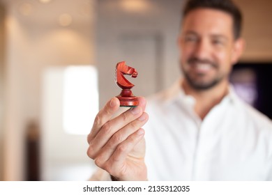 Young Confident Businessman Holding Chess Dark Horse Indoors, Successful Strategy Concept