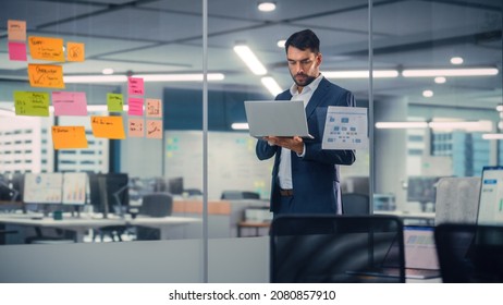 Young Confident Businessman Using Laptop Computer in Modern Office. Stylish Manager in a Suit Working on Commercial, Financial and Marketing Projects. Sales Specialist Browsing Internet, Emails.