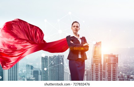 Young confident businesswoman wearing red cape against modern city background - Powered by Shutterstock