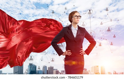 Young confident businesswoman wearing red cape against modern city background - Powered by Shutterstock