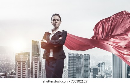 Young confident businesswoman wearing red cape against modern city background - Powered by Shutterstock