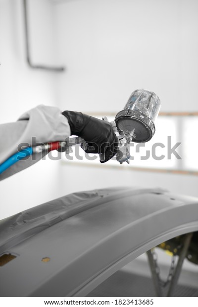 young\
confident caucasian auto mechanic man spraying varnish at car, in\
protective mask and eyewear at work. automobile, car industry. wash\
and coating business with ceramic coating\
polishing