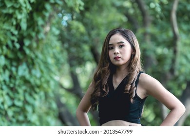 A Young Confident Filipina Woman In Her Early 20s Posing At The Park.