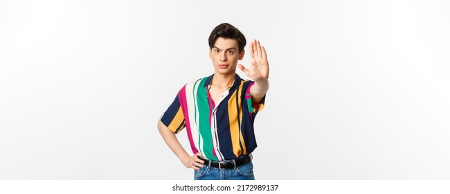 Young Confident Gay Man Saying No, Showing Stop Sign And Looking Displeased, Standing Over White Background