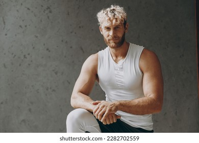 Young confident happy masculine strong sporty athletic sportsman man wearing white tank shirt black shorts leggings stand on knee looking camera warm up training indoor at gym. Workout sport concept - Shutterstock ID 2282702559