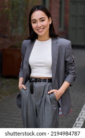 Young Confident Stylish Successful Smiling Elegant Professional Leader Asian Business Woman, Female Executive Manager, Entrepreneur Wearing Suit Looking At Camera, Vertical Outdoor Portrait.