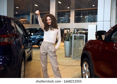 Young Confident Successful Woman With Raised Arm Holding Keys Looking At Camera, Close Up Photo. Success, Loan, Present, Gift From Boyfriend