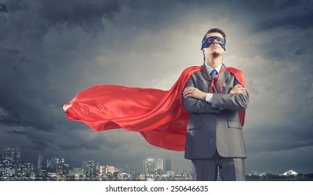 Young confident super businessman in mask and cape - Powered by Shutterstock