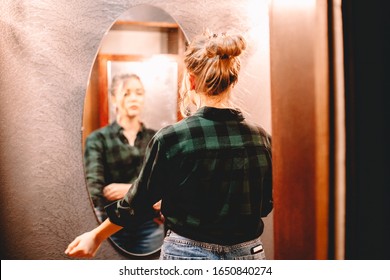 Young Confident Woman Looking At Herself In The Mirror While Standing In Hallway At Home Getting Ready Before Going Out