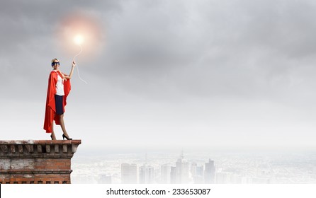 Young Confident Woman In Red Cape And Mask