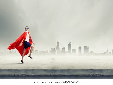 Young Confident Woman In Red Cape And Mask